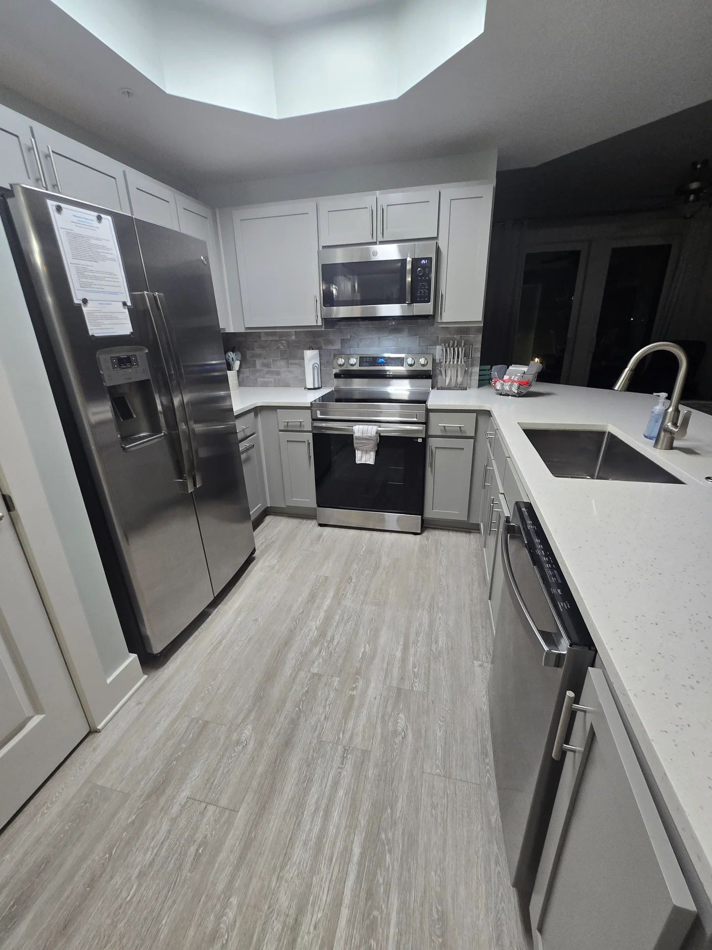 Kitchen with white cabinets, stainless appliances, and a white counter
